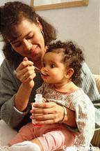 Lady giving medicine to baby